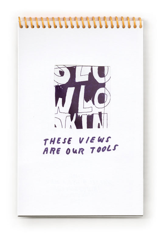 An open spread of a vertically bound zine, Risograph printed in purple ink on white paper, with a bright yellow coil. The top page has a photograph of the artist holding a viewfinder with a triangular cut out up to their face so all you see is their eye. The bottom half is a handwritten page of text about Corita Kent. 